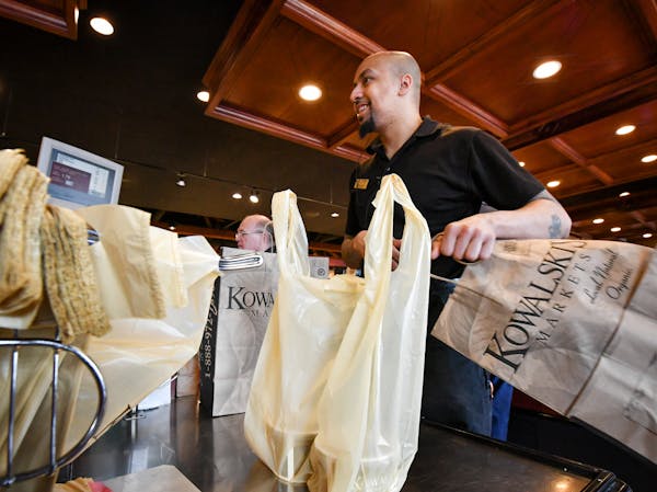 Kowalski's employee bags groceries.