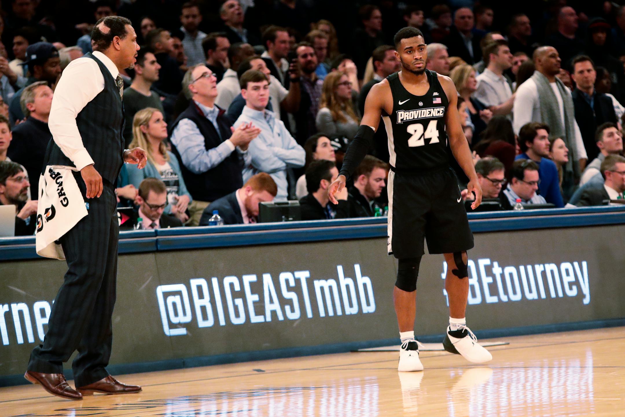 Providence coach Ed Cooley, left, talked to Kyron Cartwright -- while sporting a towel to cover his ripped pants during the Big East tournament.