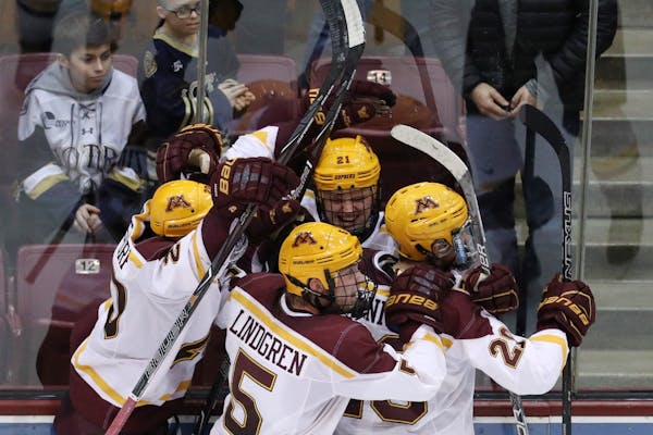 Minnesota Golden Gophers forward Casey Mittelstadt (21) celebrated with his teammates after scoring the game winning goal on Notre Dame Fighting Irish