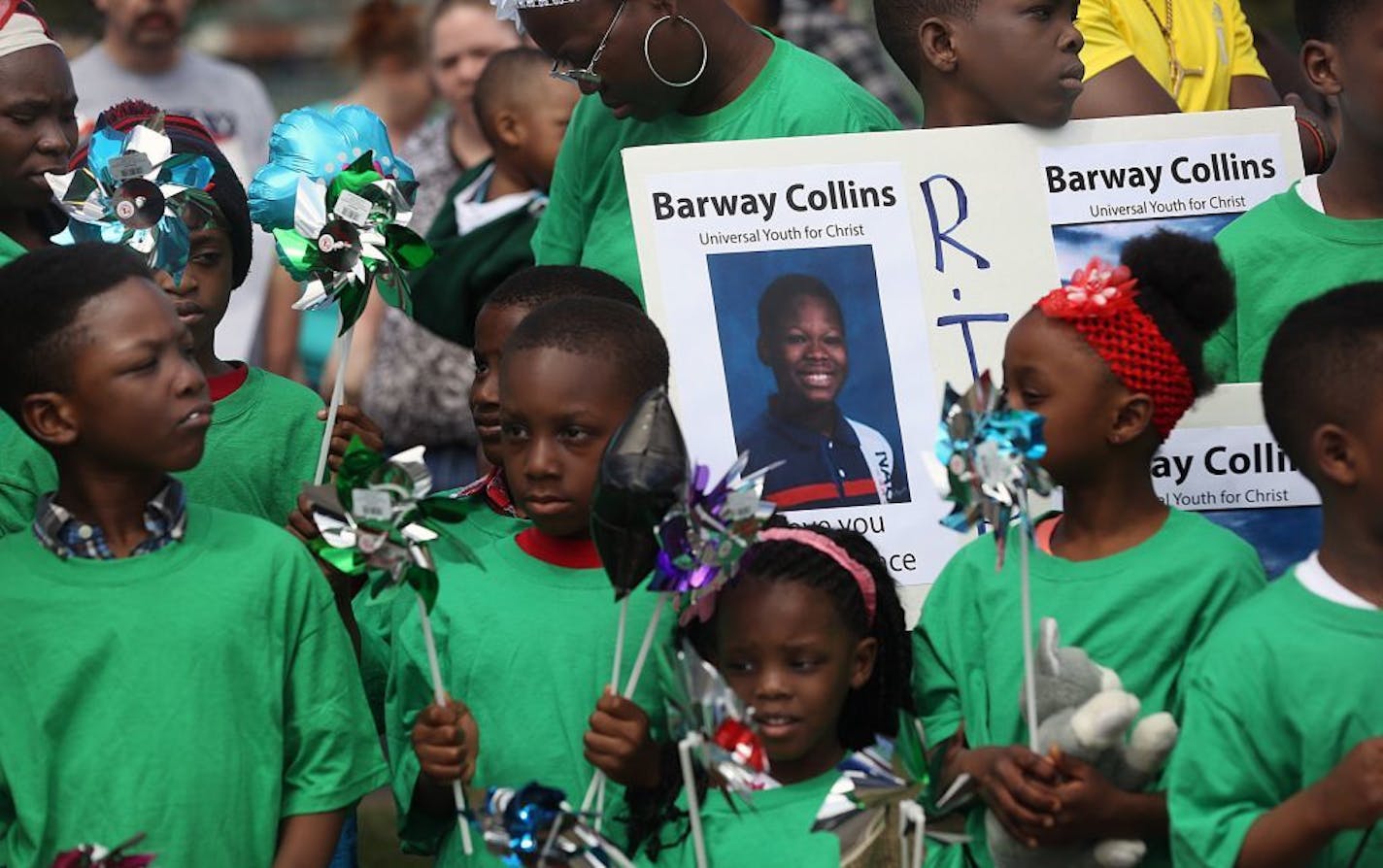 Children held signs and mementos during the emotional vigil for Barway Collins.