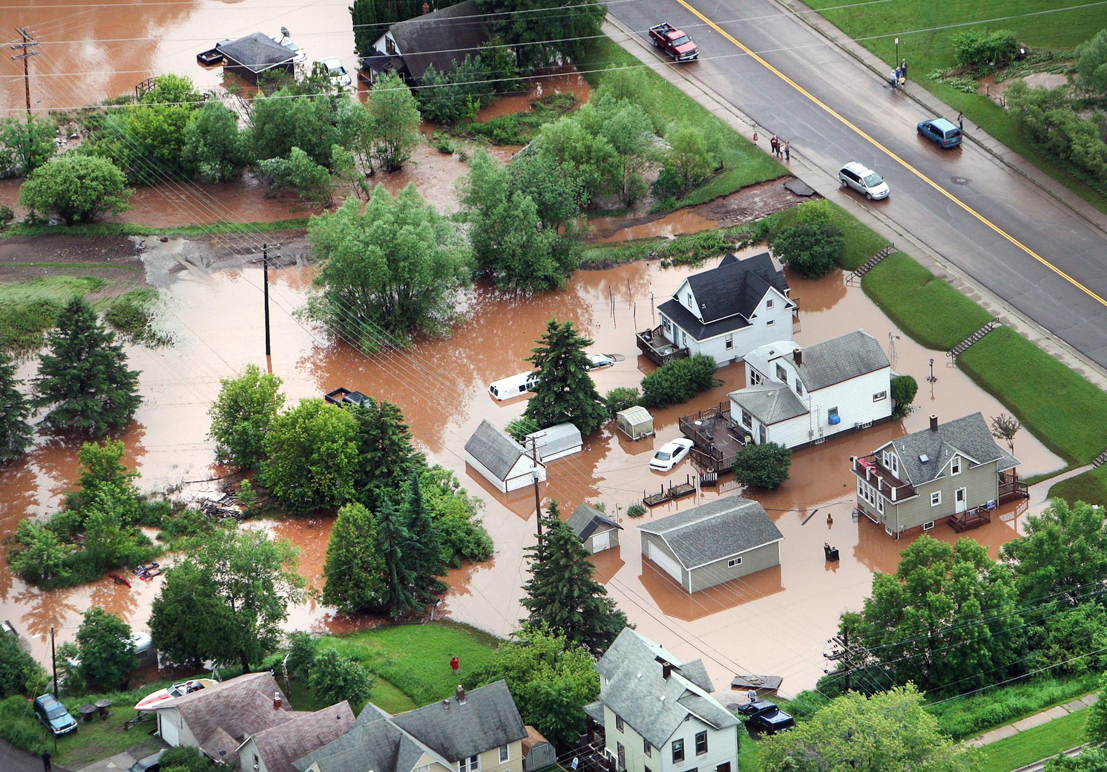 In this aerial photo, waters from an overflowing creek inundate homes in the Irving Park neighborhood of Duluth, Minn., June 20, 2012.