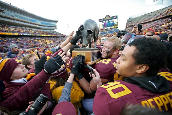 Minnesota's tight end Maxx Williams (88), center, celebrated with the "Floyd of Rosedale," trophy after the Gophers defeated the Iowa Hawkeyes 51-14, 