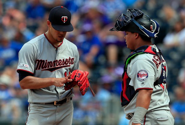Twins starting pitcher Jose Berrios, left, shows his blistered finger to catcher Willians Astudillo during the eighth inning
