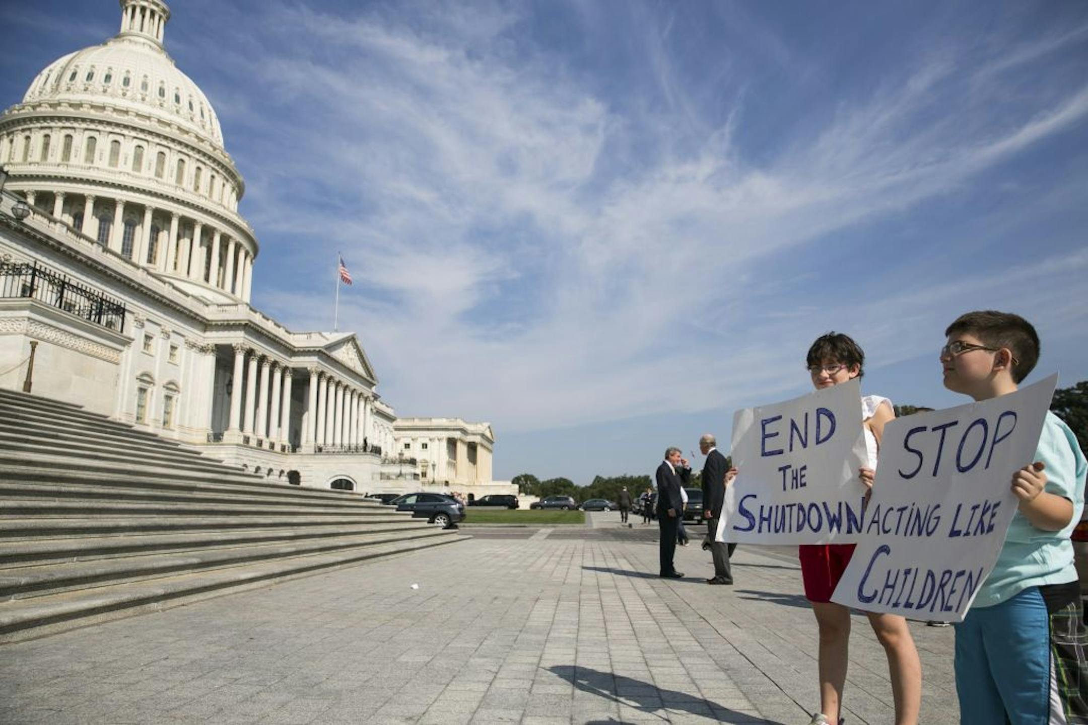 Riley Marulis, 13, left, and her brother, Jackson, 11, hold signs at the steps of the Capitol in response to the fifth day of the government shutdown in Washington, Oct. 5, 2013. Lawmakers prepared to work through a second weekend on Saturday with a House Republican strategy of passing a series of smaller spending measures on popular topics in an effort to pressure Democrats to reopen at least portions of the government.