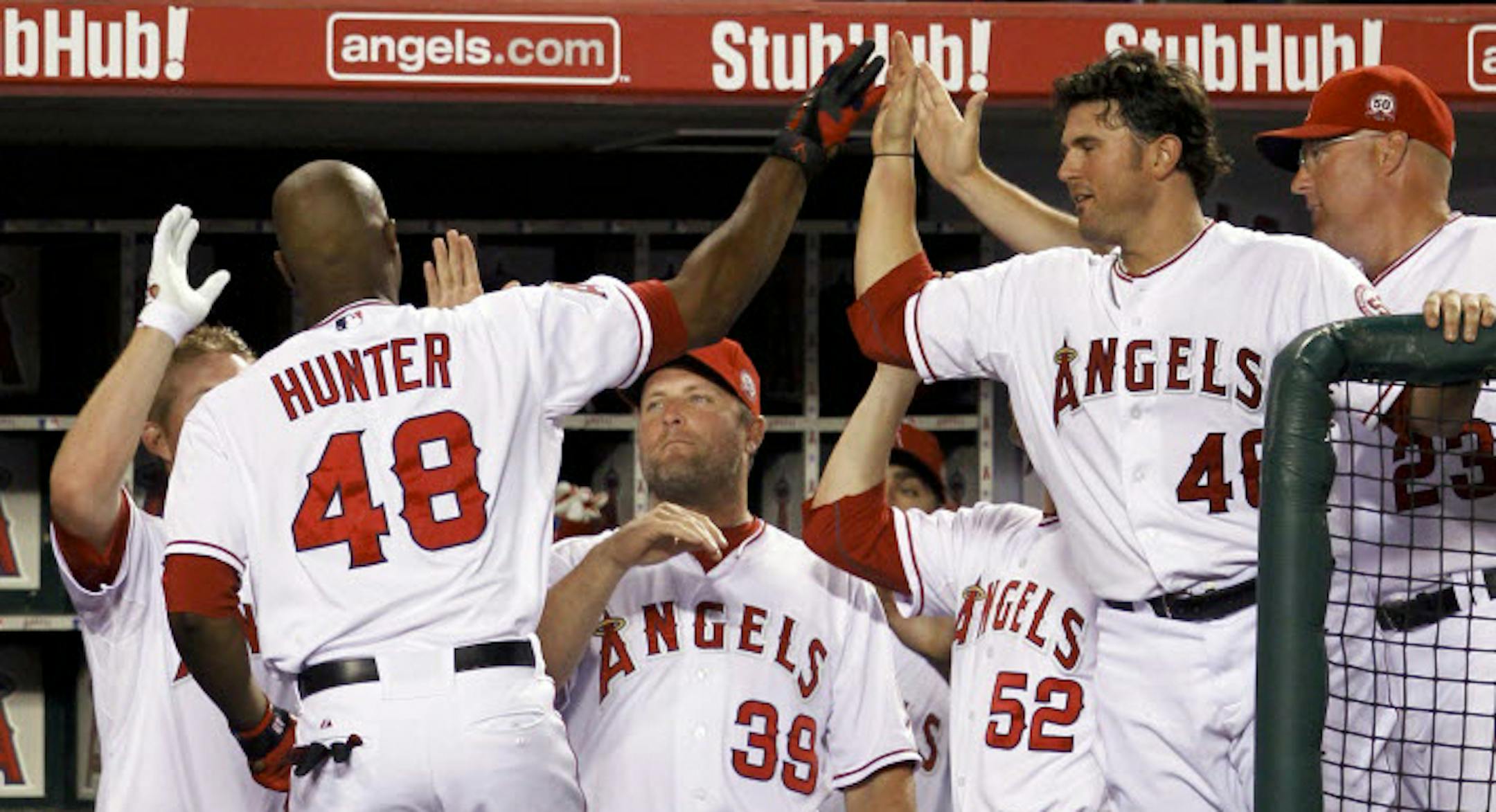 Los Angeles Angels' Torii Hunter is greeted in the dugout after a home run against the Twins during the fifth inning.