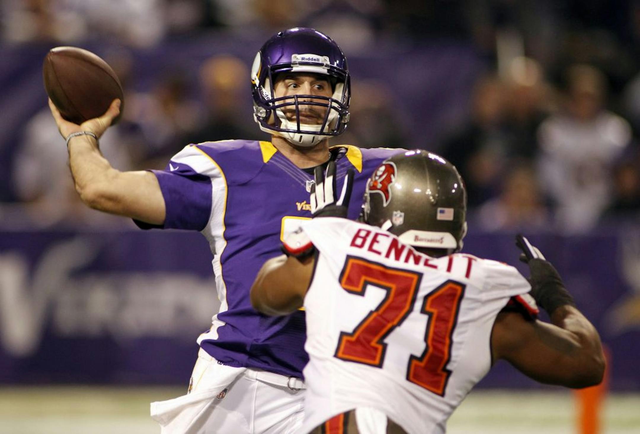 Minnesota Vikings quarterback Christian Ponder, left, throws a pass over Tampa Bay Buccaneers defensive end Michael Bennett during the first half of an NFL football game Thursday, Oct. 25, 2012, in Minneapolis.