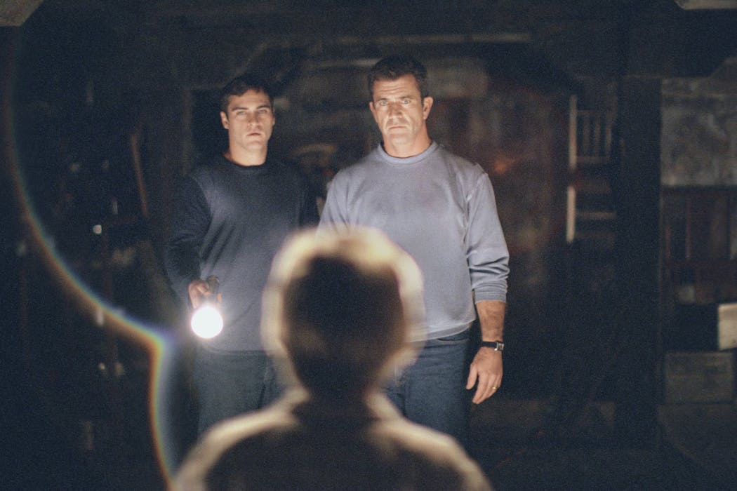 The lives of Graham Hess (Mel Gibson, right) and his brother, Merrill (Joaquin Phoenix, left) are changed forever after finding an intricate pattern of circles and lines carved into their crops in “Signs”