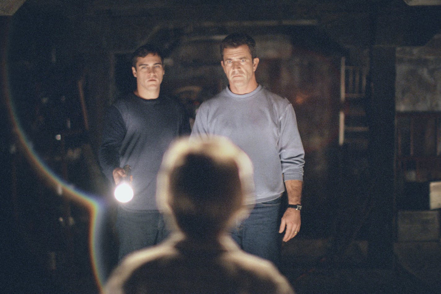 The lives of Graham Hess (Mel Gibson, right) and his brother, Merrill (Joaquin Phoenix, left) are changed forever after finding an intricate pattern of circles and lines carved into their crops in "Signs"