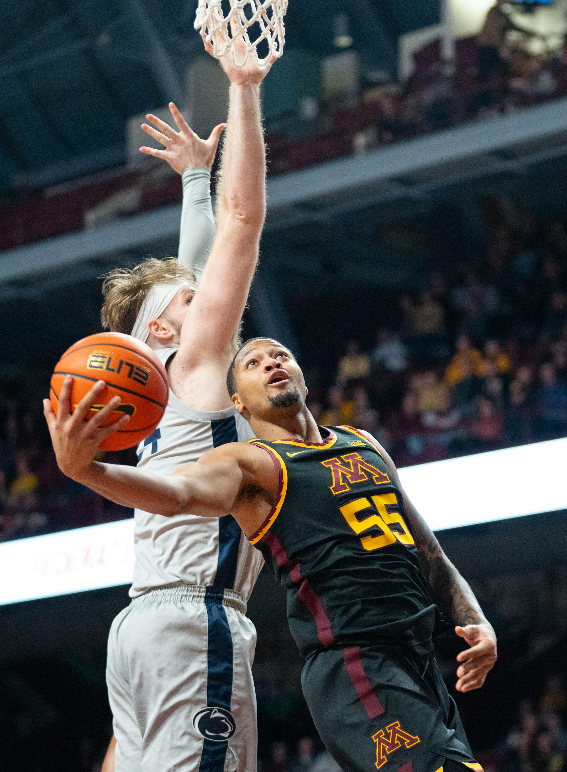 Minnesota guard Ta'lon Cooper (55) attempts a layup while being guarded by Penn State forward Michael Henn (24) in the first half.
