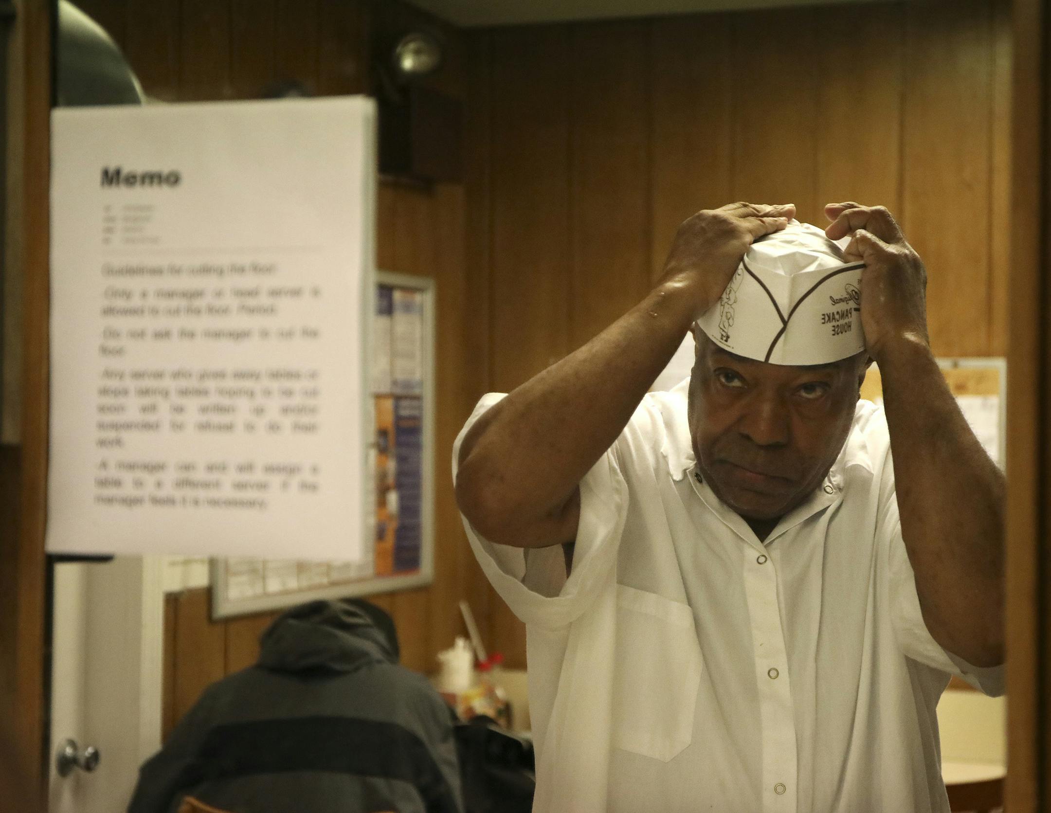 Othea Loggan, a busboy at Walker Bros Pancake House, where he has worked for 54 years, adjusts a fresh, clean white paper hat for in a back room at Walker Bros. Original Pancake House on Thursday, May 23, 2018 in Wilmette, Ill. Loggan works at the restaurant four days a week. He leaves his home around 3:45 a.m. for a two-hour commute, taking two trains and a bus so that he can arrive by 6 a.m. (Stacey Wescott/Chicago Tribune/TNS) ORG XMIT: 1239622