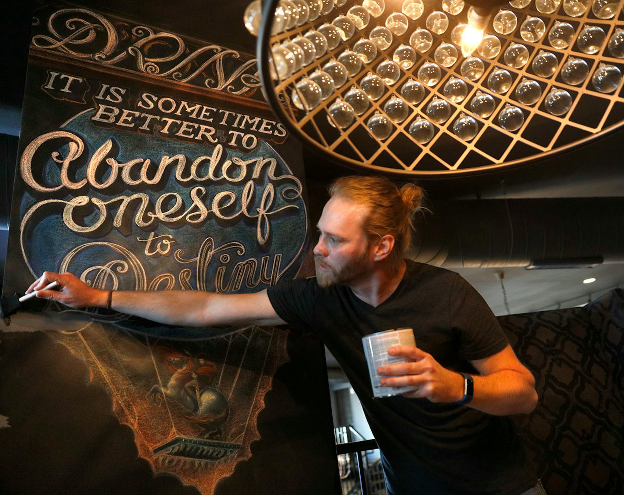 Adam Dennis works on his murals at Coup d'Etat restaurant in Uptown. Dennis' work include Smack Shack and the Pourhouse and is done with chalk and spray paint.