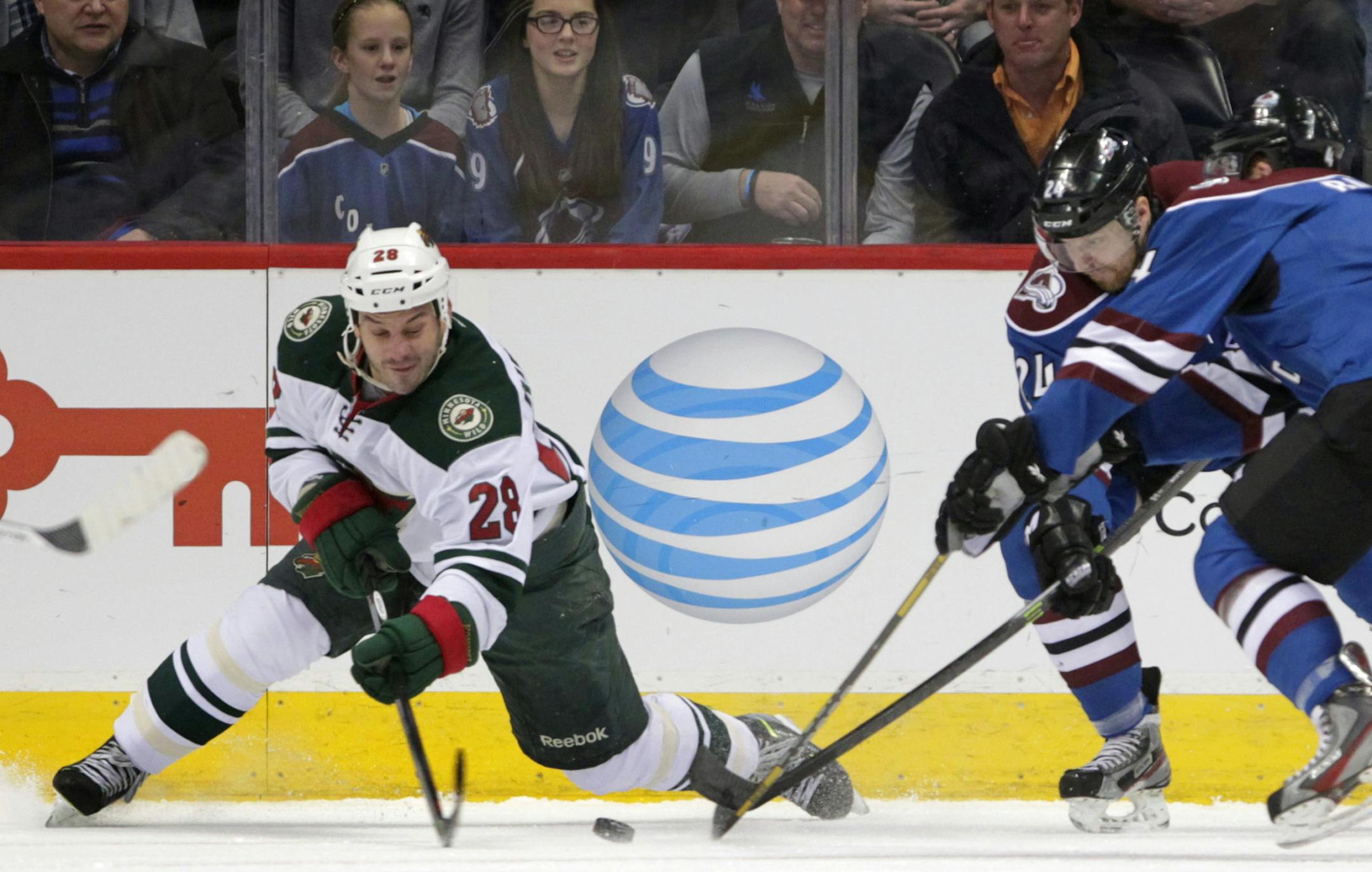 Minnesota Wild center Zenon Konopka (28) reaches for the puck against Colorado Avalanche right wing Marc-Andre Cliche (24) and Avalanche defenseman Tyson Barrie, right, during the first period of an NHL hockey game in Denver on Saturday, Dec. 14, 2013. (AP Photo/Joe Mahoney)