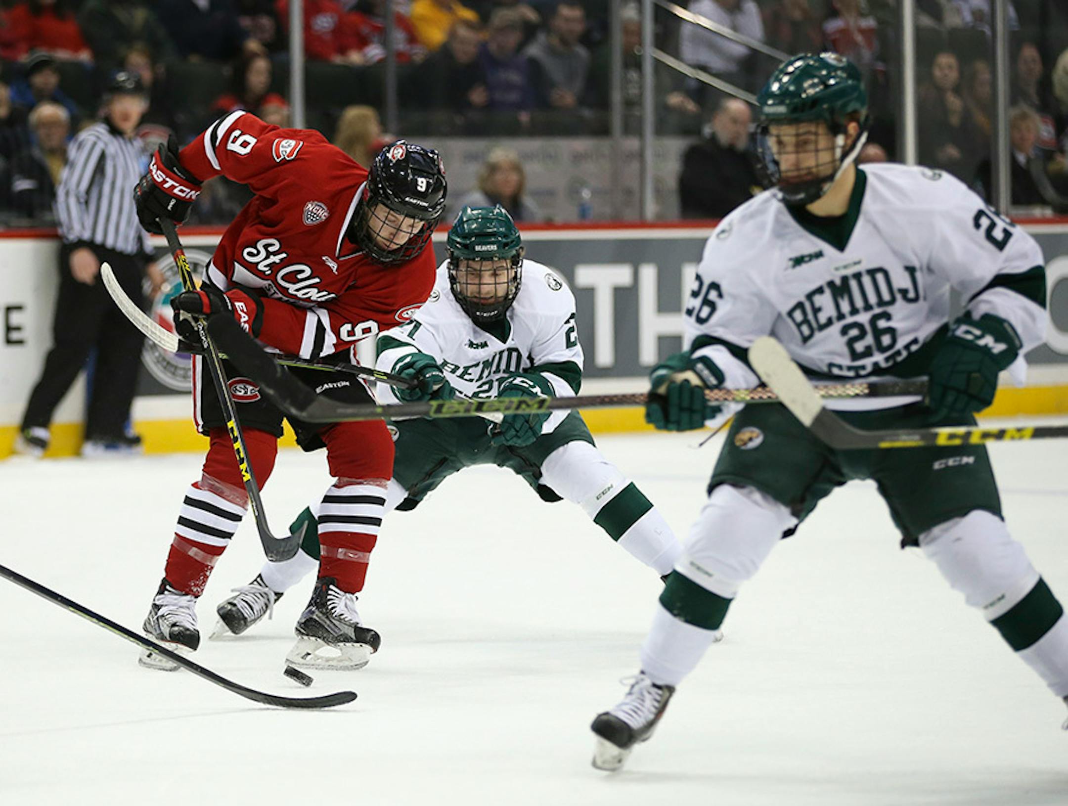 The Beavers' Gerry Fitzgerald (21) tried to check the Huskies' Joey Benik (9) off the puck in the first period Sunday afternoon.