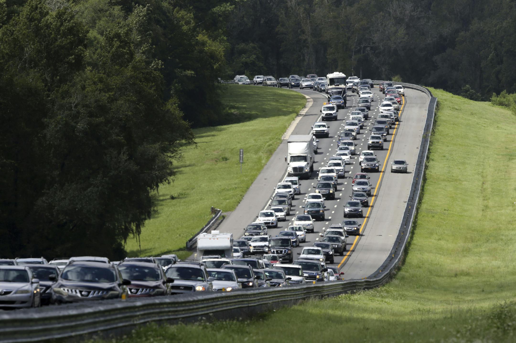 A car rides in the shoulder to pass other cars in evacuation traffic on I-75 N, near Brooksville, Fla., in advance of Hurricane Irma, Saturday, Sept, 9, 2017. (AP Photo/Gerald Herbert)