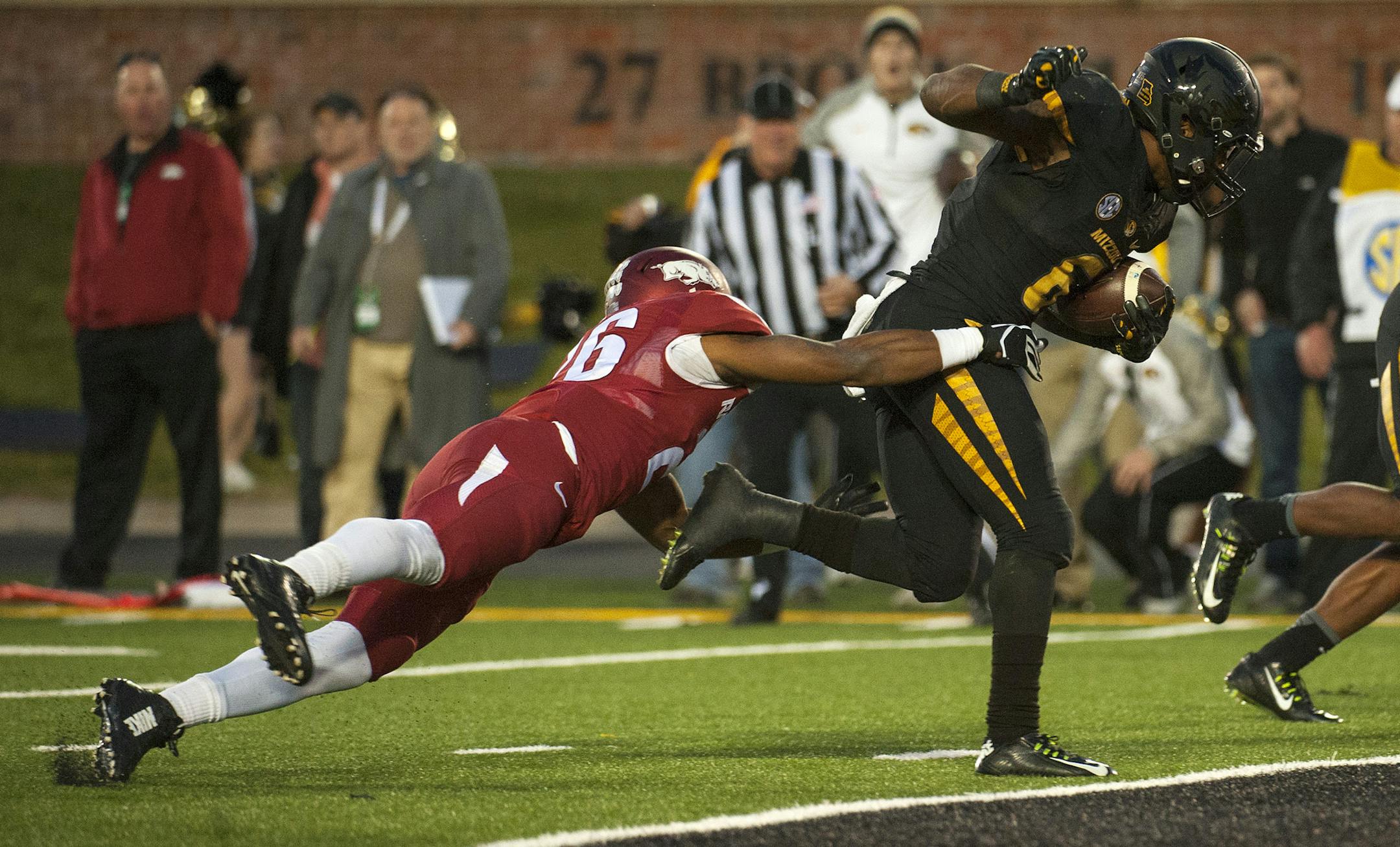 Missouri running back Marcus Murphy, right, drags Arkansas's Rohan Gaines into the end zone as he scores the winning touchdown during the fourth quarter of an NCAA college football game Friday, Nov. 28, 2014, in Columbia, Mo. Missouri won 21-14. (AP Photo/L.G. Patterson)