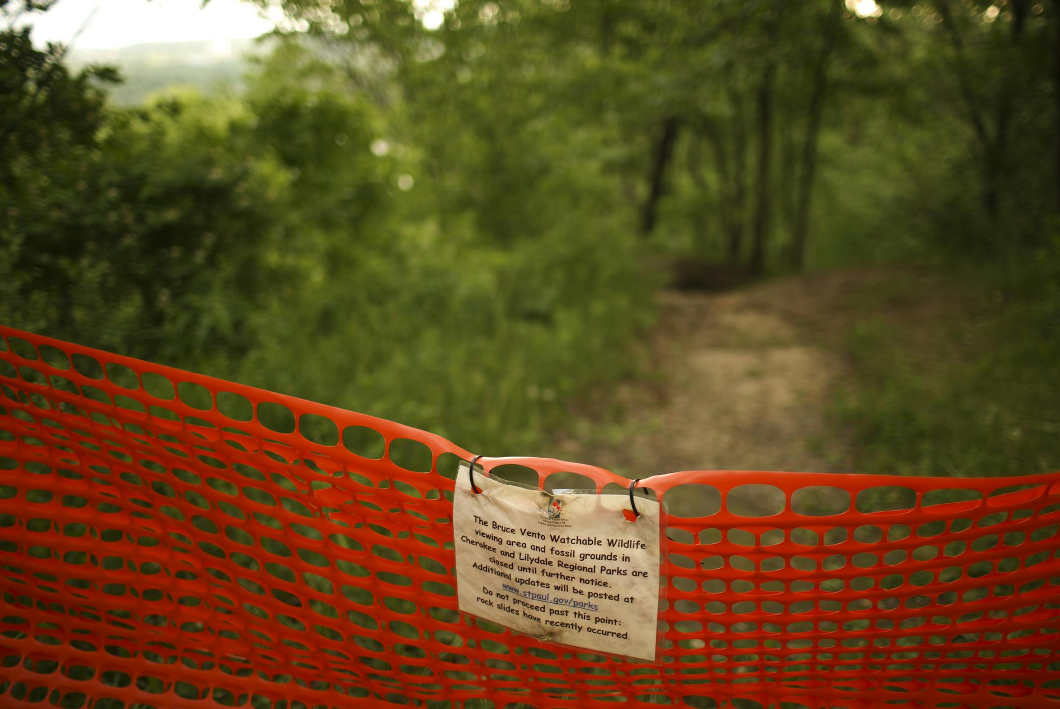 A temporary fence and a sign in Cherokee Park announce the closing of trails that make up the Bruce Vento Watchable WIldlife viewing area and the fossil grounds above Lilydale Regional Park.