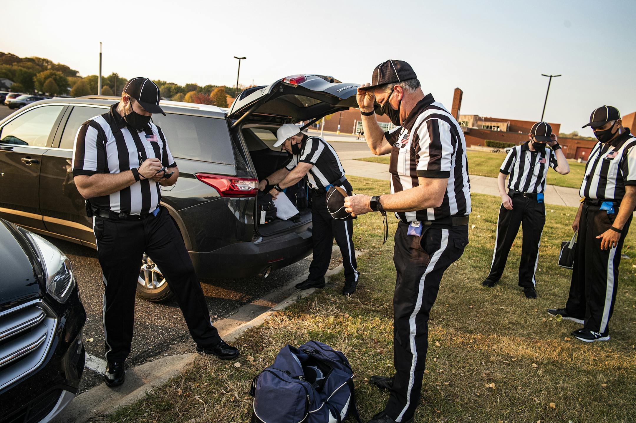 A parking lot gave game officials (left to right) Jason Vogt, Andrew Aller, Brian Grandstand, Dan Sigl and David Rivera distance to gear up for Friday's game at Apple Valley. Aller (above) included a face mask among his required gear.