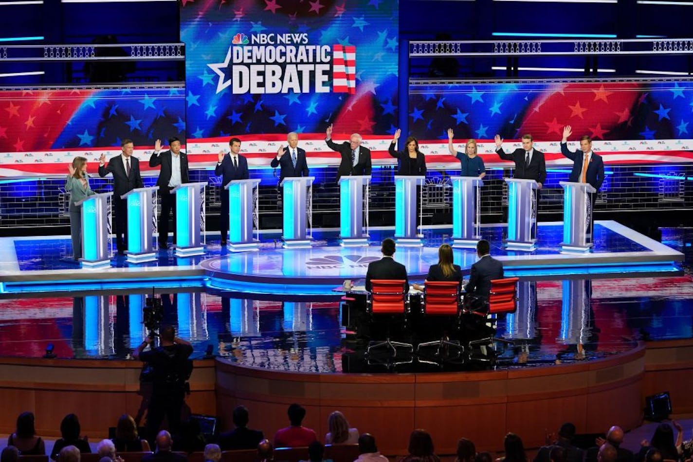 Candidates raised their hand when asked if their healthcare plan would cover undocumented immigrants during the Democratic presidential debate in Miami on Thursday night, June 27, 2019. From left: Marianne Williamson; former Gov. John Hickenlooper of Colorado; Andrew Yang; Mayor Pete Buttigieg of South Bend, Ind.; former Vice President Joe Biden; Sen. Bernie Sanders (I-Vt.); Sen. Kamala Harris (D-Calf.); Sen. Kirsten Gilibrand (D-N.Y.); Sen. Michael Bennet (D-Colo.); and Rep. Eric Swalwell (D-Ca