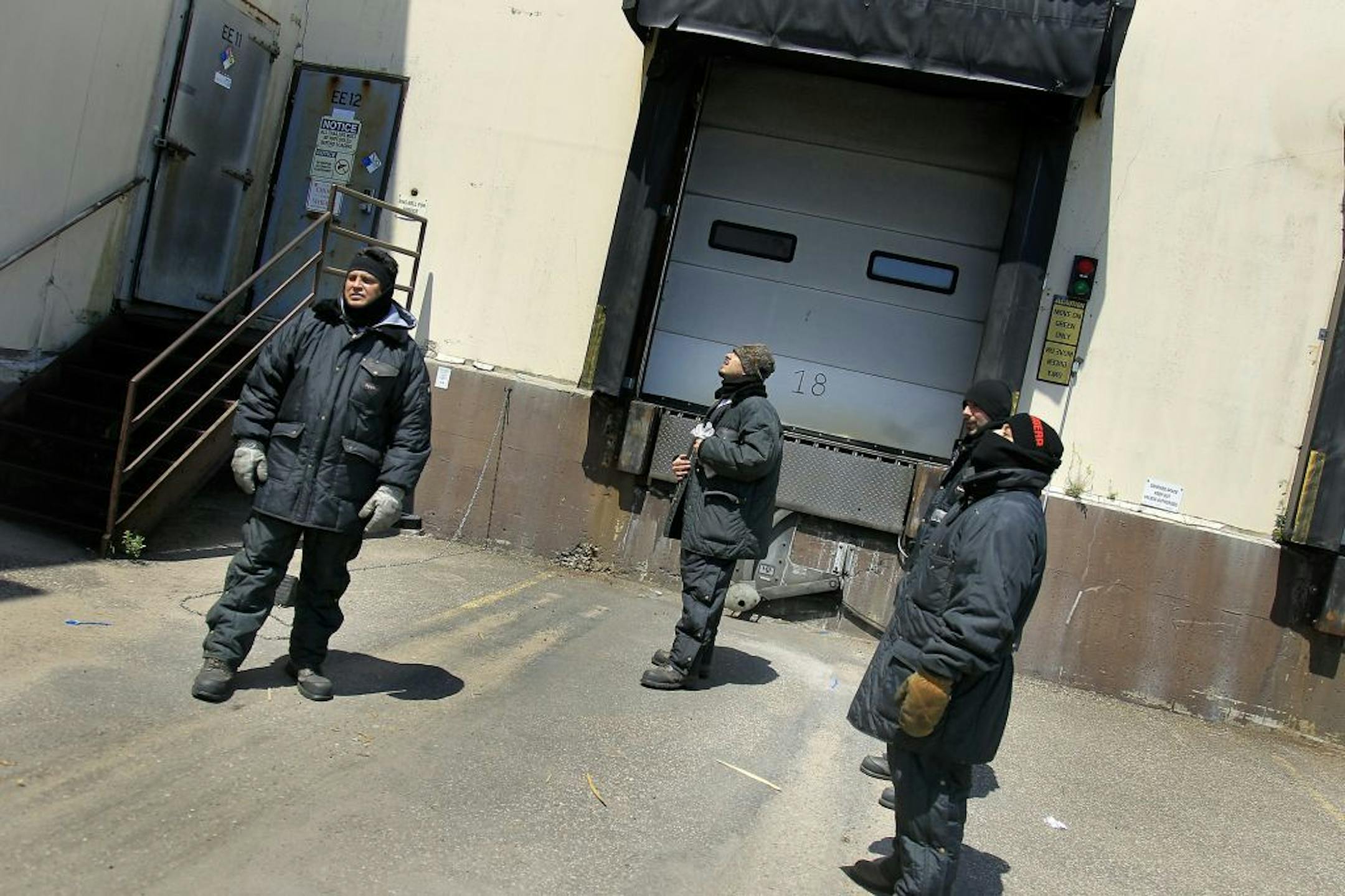 Robert Diaz, from left, Dan Growchowski, Jarred Novotny, and Tomas Jaques of Americold Logistics, took to the heat outside to warm up from their jobs that entail spending most of the day in 5 below zero termperatures, Monday, July 16, 2012 during another potentially record setting day of heat in the Twin Cities. (ELIZABETH FLORES/STAR TRIBUNE) ELIZABETH FLORES � eflores@startribune.com