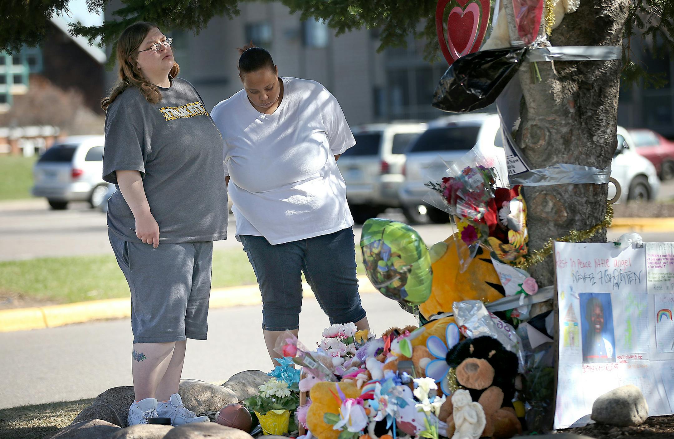 Rachel Volk, left, and Ashely Allen made a visit to a makeshift memorial site and said they have been coming to this particular tree every day to remember Barway Collins, Tuesday, April 14, 2015 in Crystal, MN. ] (ELIZABETH FLORES/STAR TRIBUNE) ELIZABETH FLORES • eflores@startribune.com