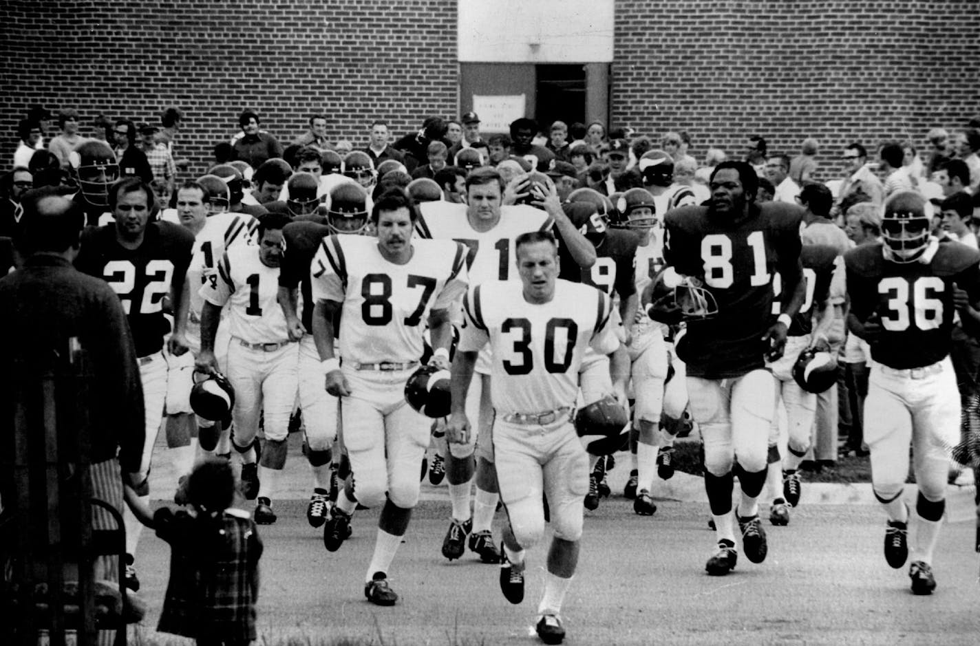 July 26, 1972 Bill Brown (30) led his Minnesota Vikings teammates out of the dressing room and onto the field for the beginning of training camp Wednesday.