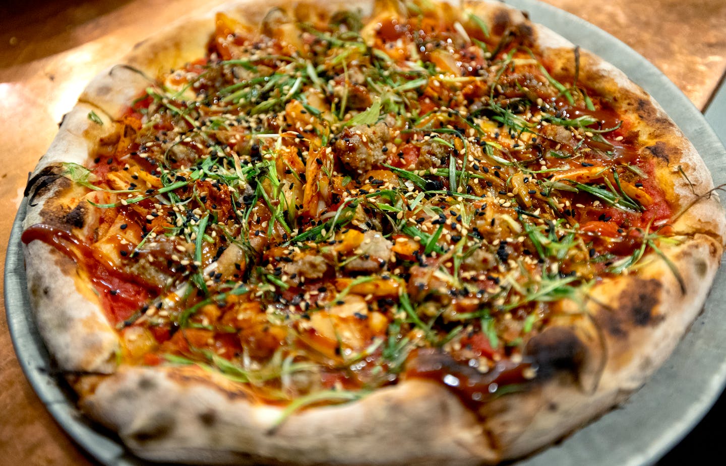 LADY ZAZA PIZZA - plum tomato sauce, korean sausage, napa kimchi, gochujang, scallion, sesame. Thursday, January 25, 2024, at Pizzeria Lola in Minneapolis, Minn.

   ] CARLOS GONZALEZ • carlos.gonzalez@startribune.com