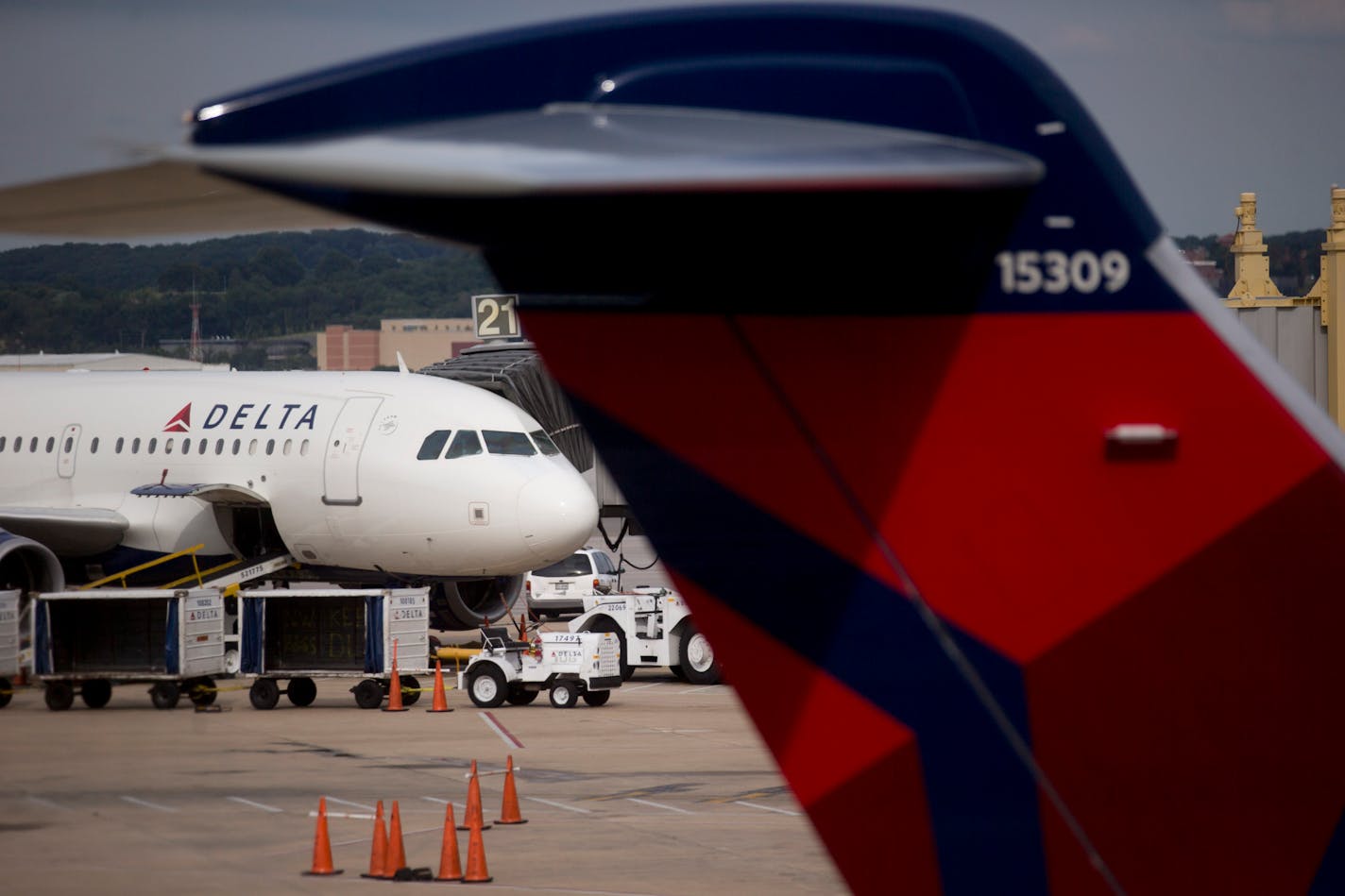 A Delta Air Lines Inc. airplane sits parked at a gate of Ronald Reagan National Airport in Washington, D.C., U.S., on Wednesday July 16, 2014. Delta Air Lines Inc., the third-largest U.S. airline, is expected to report second quarter earnings figures on July 23. Photographer: Andrew Harrer/Bloomberg