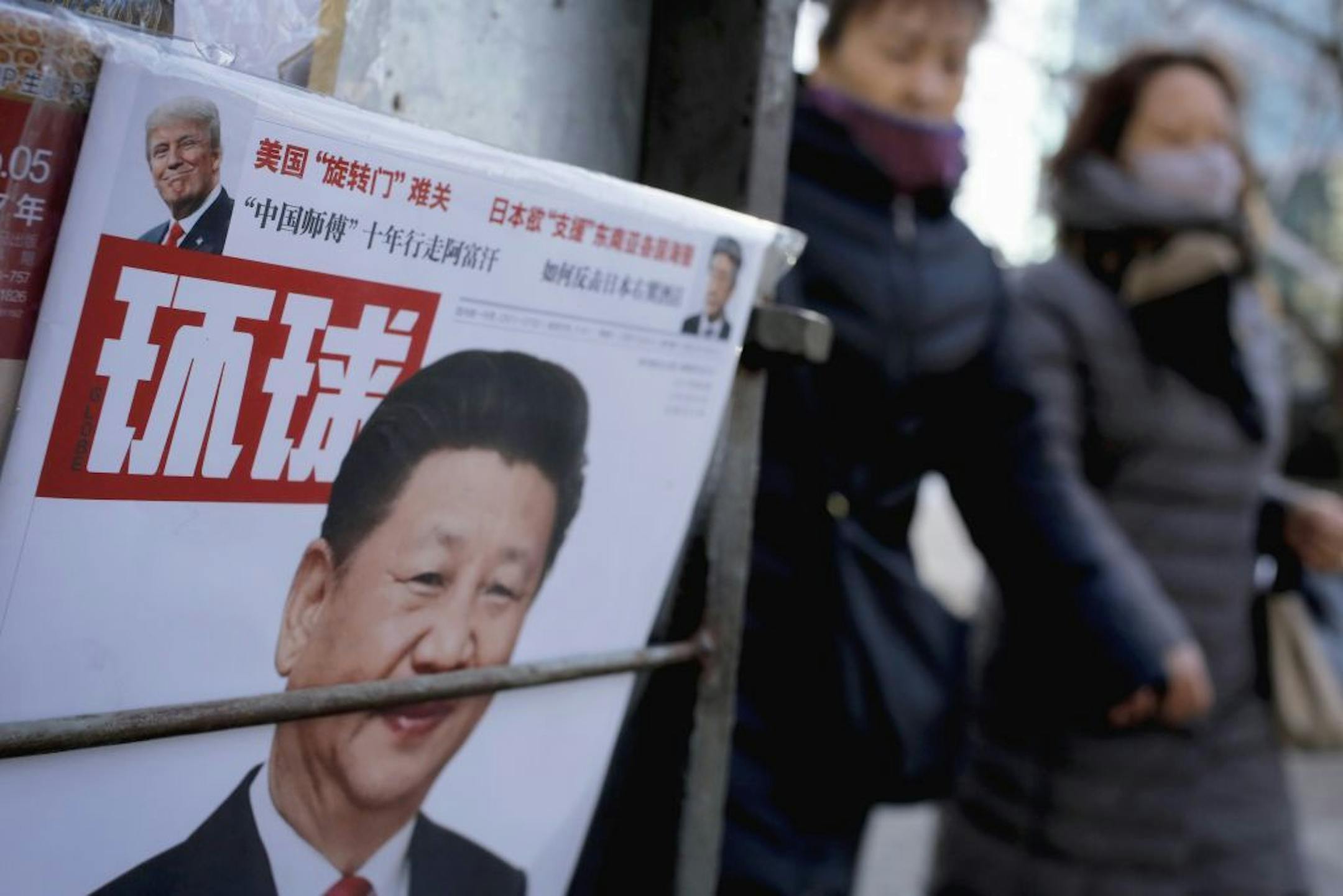 Women walk past a news stand displaying a Chinese news magazine fronting a photo of Chinese President Xi Jinping and U.S. President Donald Trump in Beijing, Thursday, Feb. 9, 2017. Trump has issued belated well-wishes to China for the Lunar New Year, the most important holiday in the world's most populous nation, saying he hoped to work with his Chinese counterpart Xi Jinping to build a "constructive relationship."