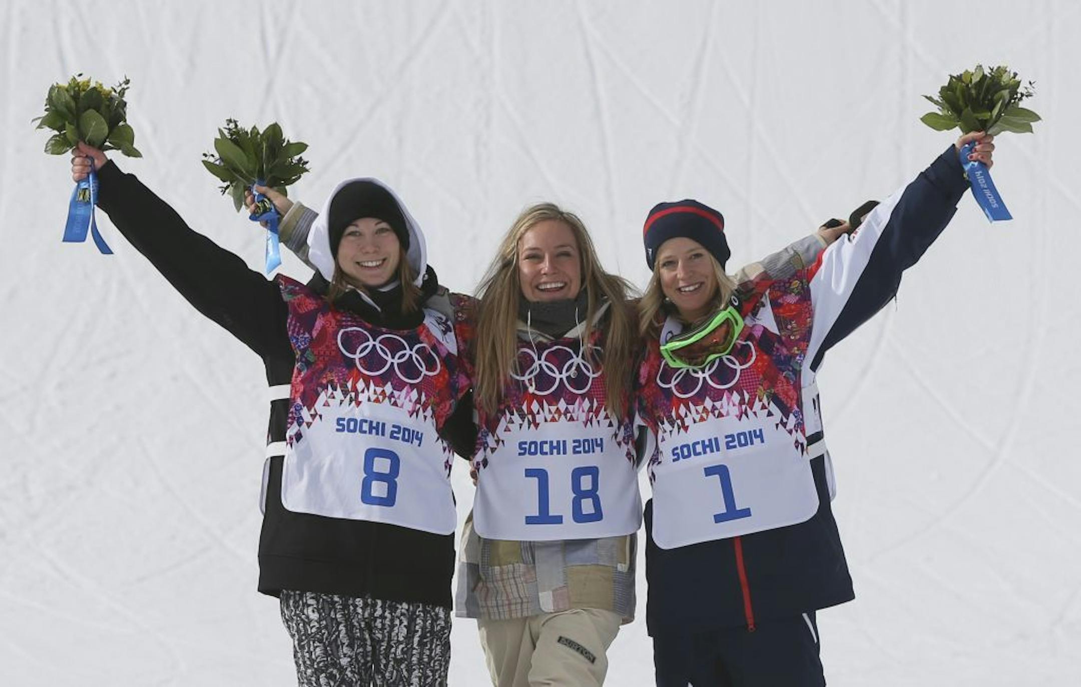 Jamie Anderson of the United States, center, celebrates with silver medalist Enni Rukajarvi of Finland, left, and bronze medalist Jenny Jones of Britain, after Anderson won the women's snowboard slopestyle final at the 2014 Winter Olympics, Sunday, Feb. 9, 2014, in Krasnaya Polyana, Russia.