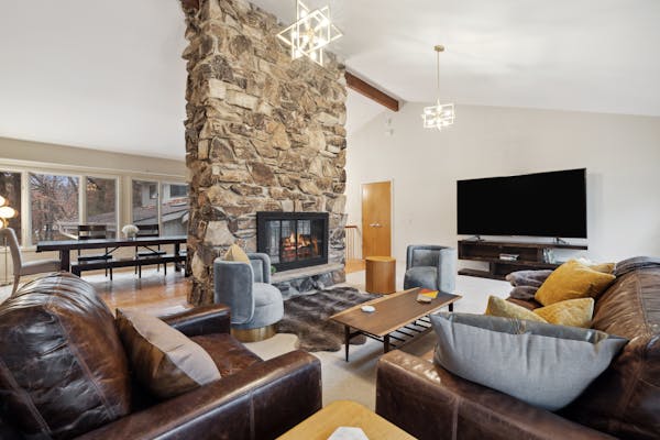 The North Oaks home features a wood-burning fireplace with custom stonework and vaulted ceilings. 