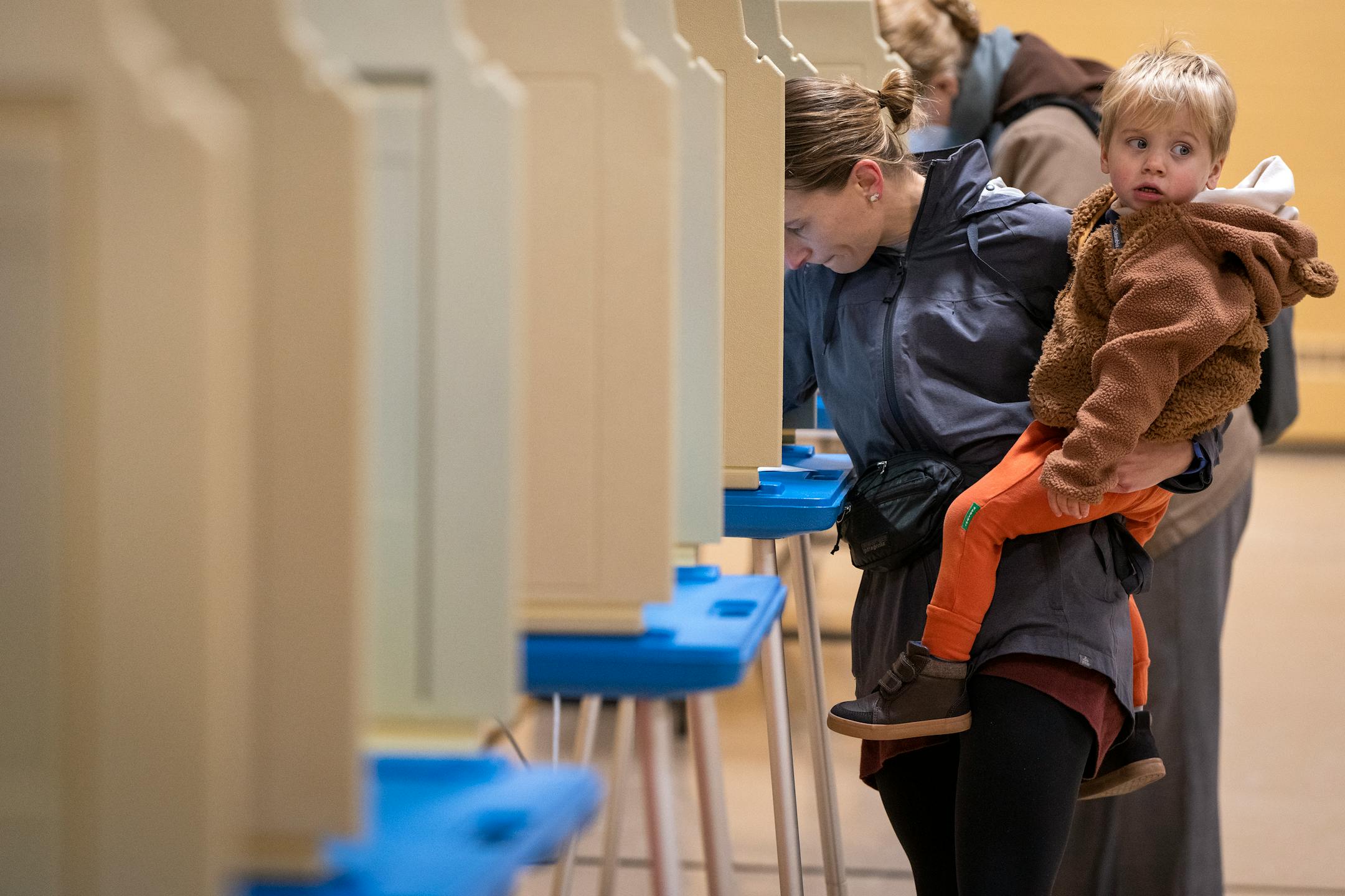 Meghan Mason holds her son Owen Ryan, 2, while voting at Gloria Dei Lutheran Church in Ward 3 of St. Paul.