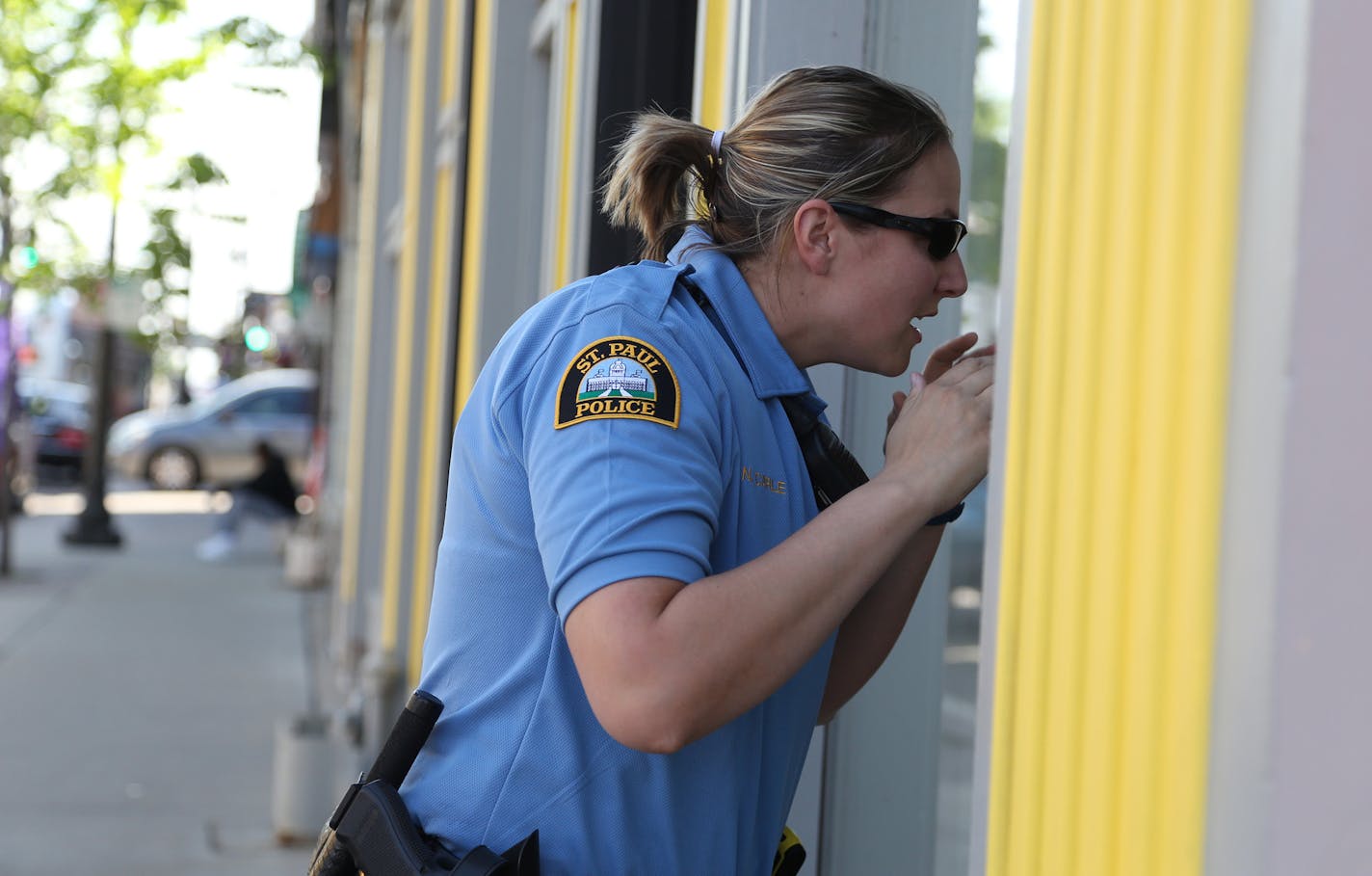 Officer Nicole Carle took a look into the restaurant Tongue and Cheek to see if there is some one to say hello to. ] (KYNDELL HARKNESS/STAR TRIBUNE) kyndell.harkness@startribune.com Shadowing officers Mitchell and Carle as they walk in the Payne Avenue area in St Paul Min., Friday, May 22, 2015.