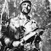 FILE - In this Feb. 26, 1957 file photo, Cuba's leader Fidel Castro stands in an unknown location in Cuba. Former President Fidel Castro, who led a re