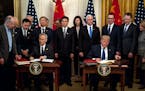 FILE — President Donald Trump, right, and Chinese Vice Premier Liu He sign an initial trade agreement in the White House in Washington, Jan. 15, 202