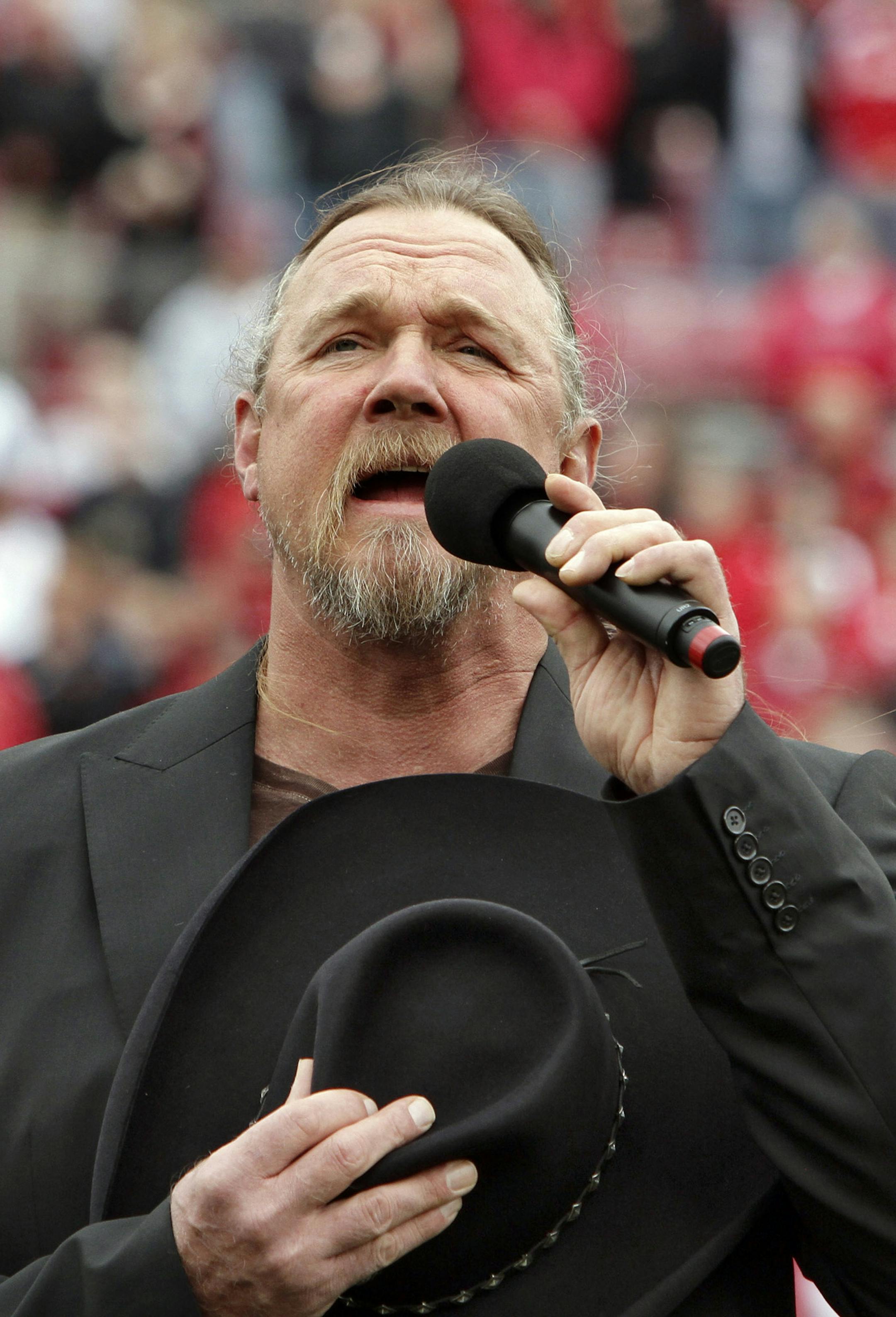 Country music artist Trace Adkins signs the national anthem before the start of the Marshall-Louisville NCAA college football game in Louisville, Ky., Saturday, Oct. 1, 2011. (AP Photo/Garry Jones) ORG XMIT: NYOTK