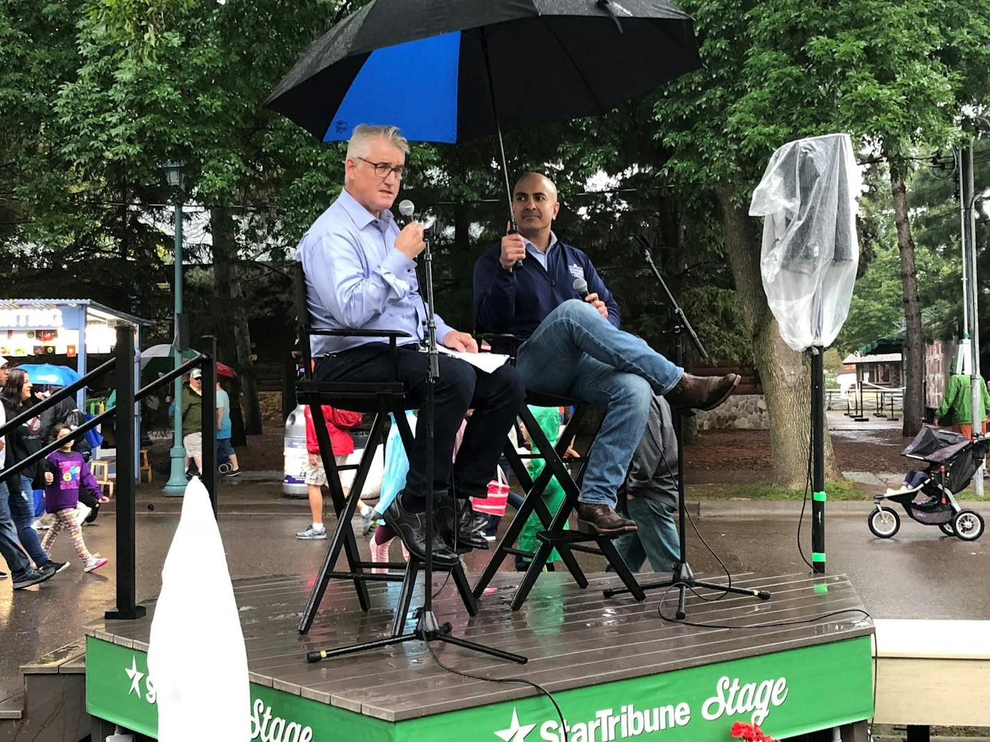 Columnist Lee Schafer, left, and Minneapolis Fed President Neel Kashkari in the rain at the Minnesota State Fair on Tuesday.