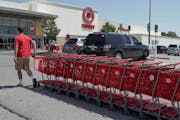 FILE - A Target employee returns shopping carts from the parking lot, in Omaha, Neb., Tuesday, June 16, 2020. Target Corp. says it's permanently incre