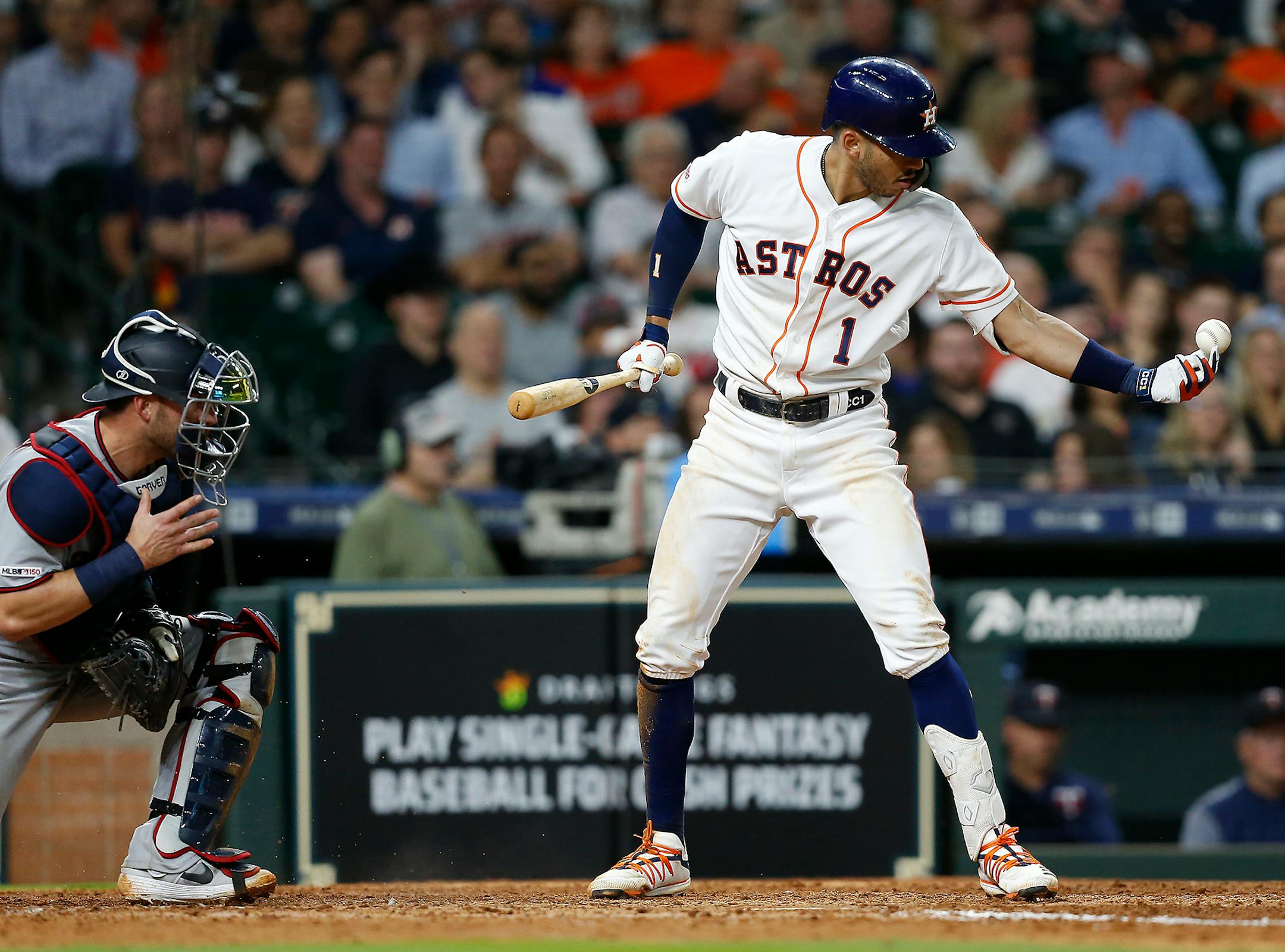 Carlos Correa reaches for a ball that was deemed in play and subsequently called out for batter interference in the seventh inning