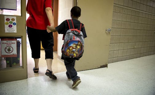 Marcy Open School principal Donna Andrews helped a young student find his classroom on the first day of classes in Minneapolis. Monday, August 26, 2013