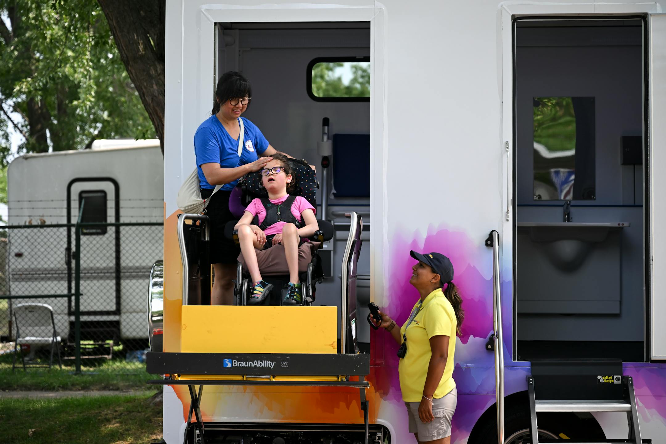 Tram Nguyen caresses her 8-year old daughter Sadie Sava's head after they utilized the fair's adult changing table.
