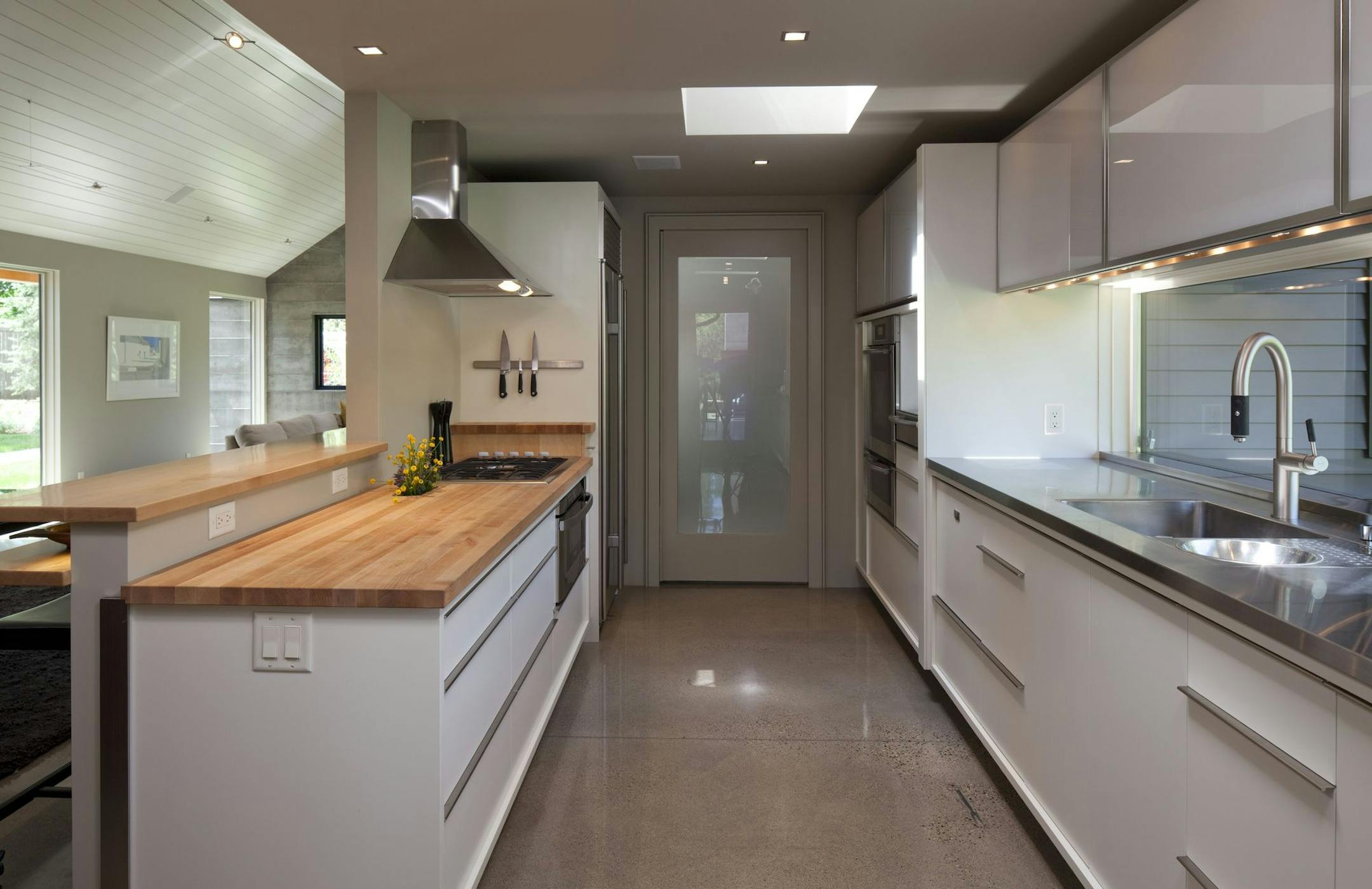 An eco-friendly galley-style kitchen features polished concrete floors and skylights, by Katherine Hillbrand, SALA Architects.