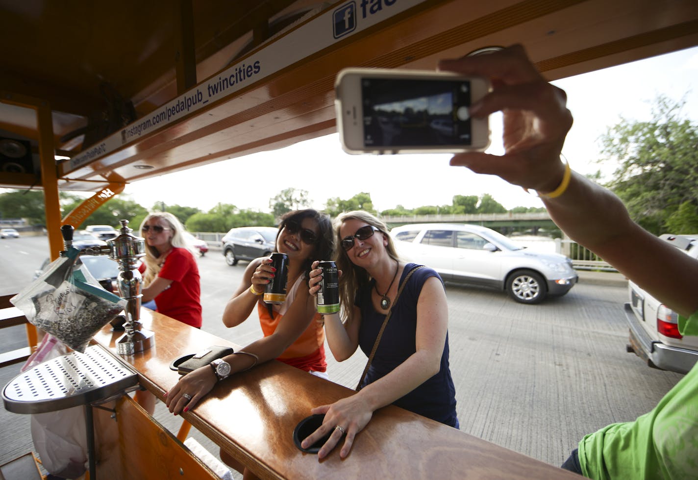 Gina Chov and Kate Curtis, right, posed for a commemorative photo as they crossed the Hennepin Ave. bridge on a Pedal Pub with a group of co-workers Thursday evening. Susan Rylance was taking the photo; Holly Anderson is at far left. ] JEFF WHEELER &#xef; jeff.wheeler@startribune.com Pedal Pubs were back on the streets Thursday night, June 25, 2015 in Minneapolis after one was hit on the Hennepin Ave. bridge the previous night.