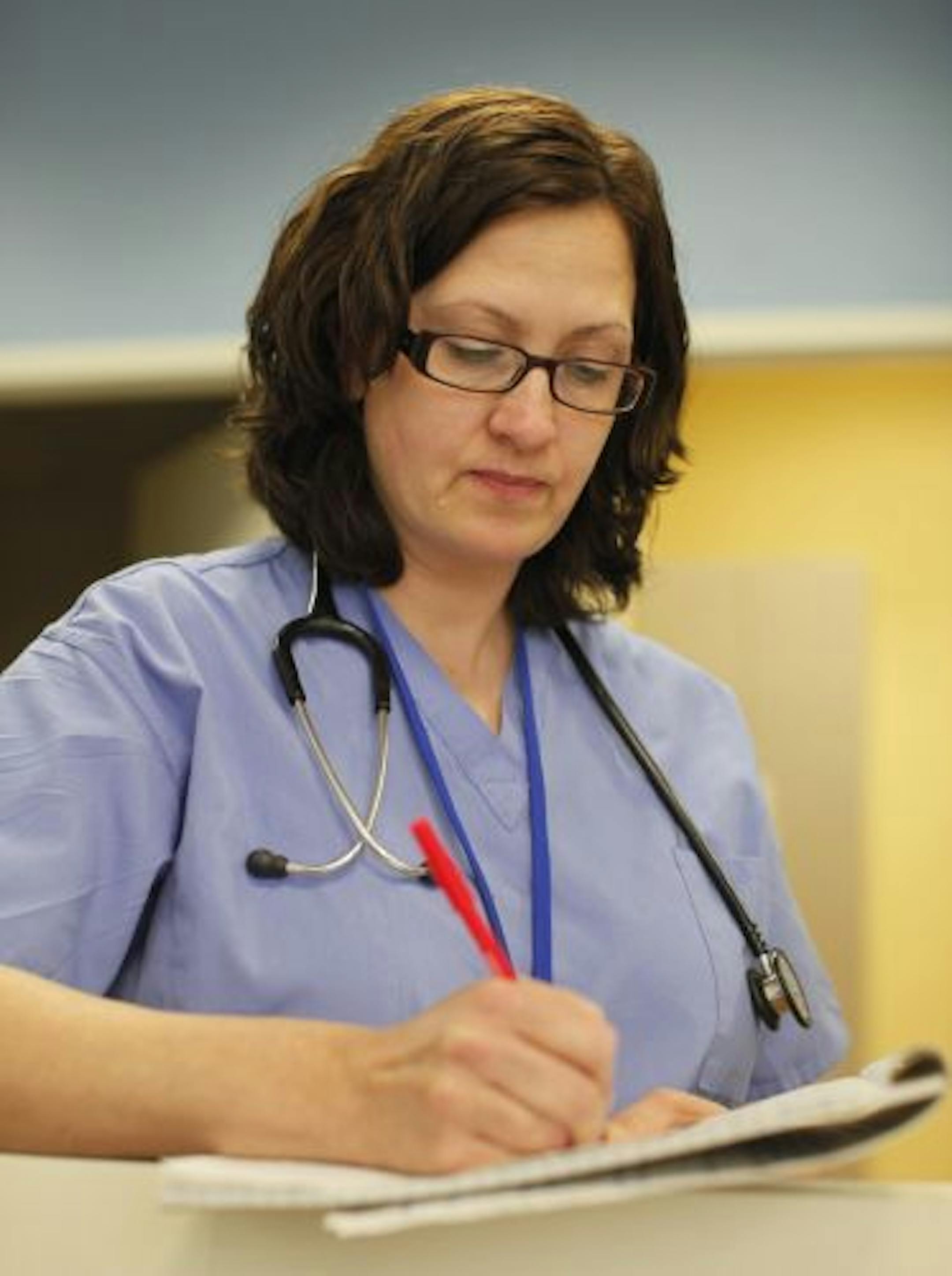 Physician assistant Brenda Baker caught up with paperwork at the retail clinic opened by HCMC at the Wal-Mart in Bloomington.