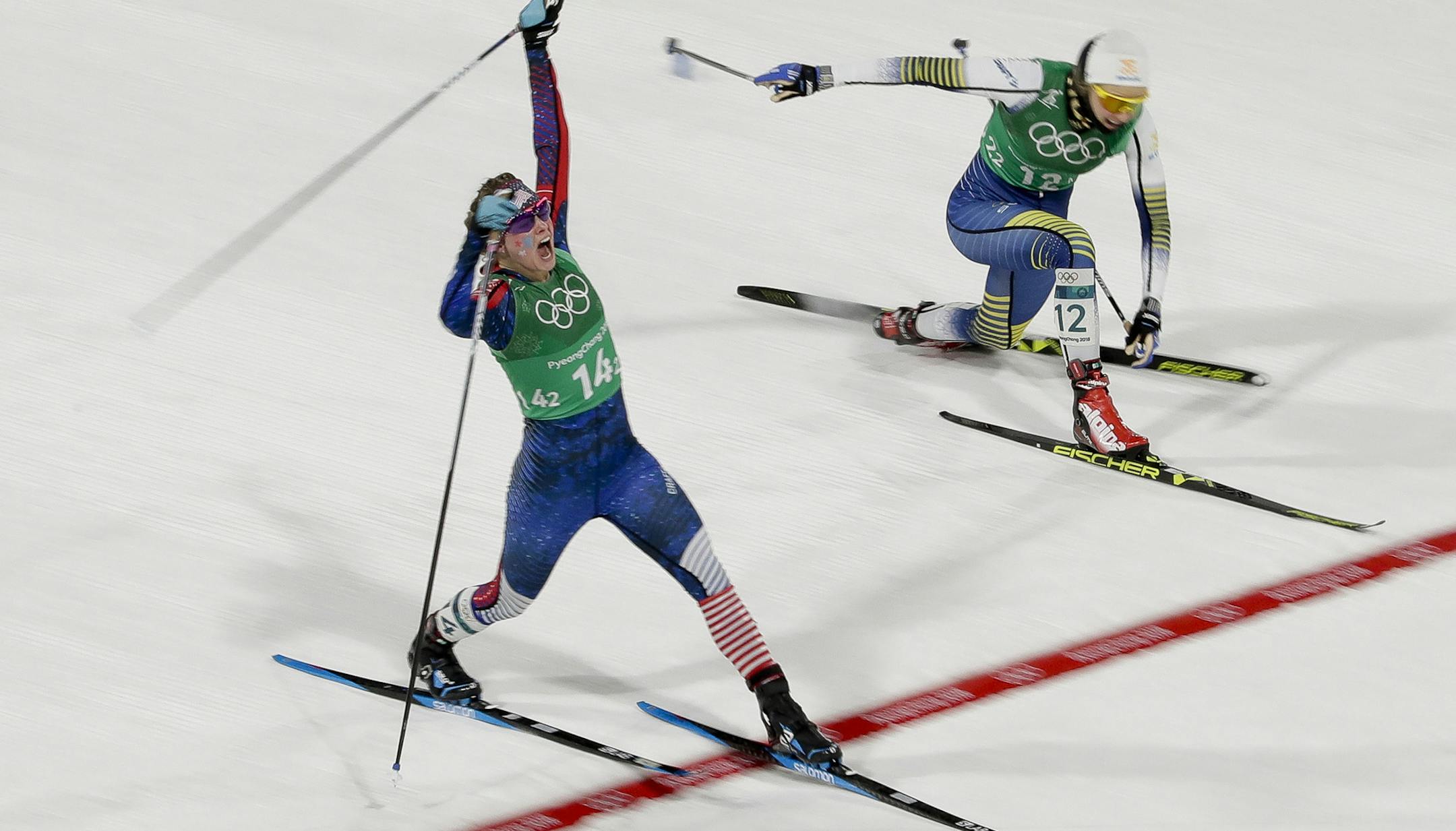 Jessica Diggins, left, of the United States, celebrates after winning the gold medal past Stina Nilsson, of Sweden, in the during women's team sprint freestyle cross-country skiing final at the 2018 Winter Olympics in Pyeongchang, South Korea, Wednesday, Feb. 21, 2018. (AP Photo/Dmitri Lovetsky) ORG XMIT: MIN2018022106412511