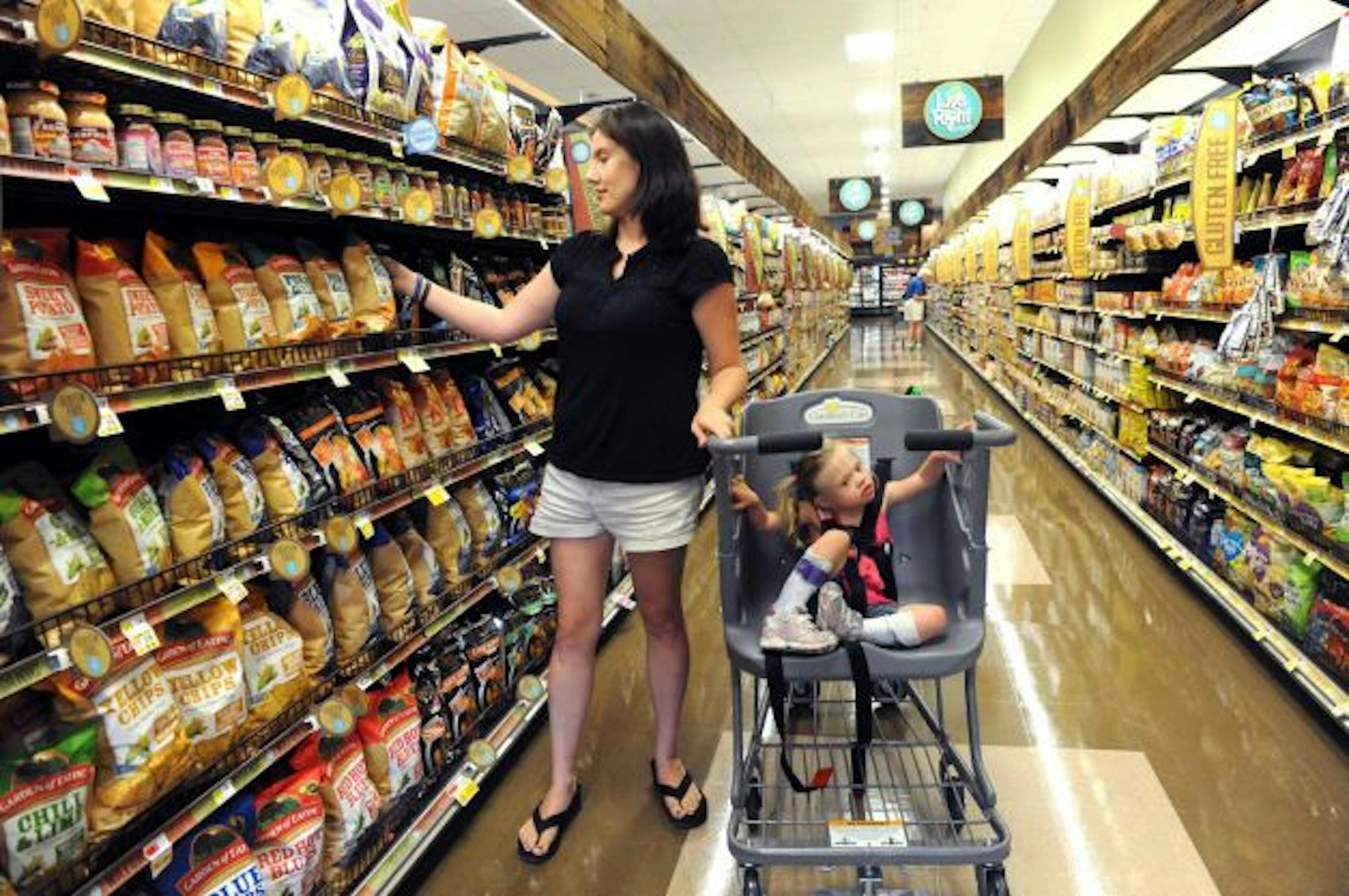 A shopper uses a Caroline's Cart on a groceries trip with her child.