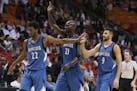 Minnesota Timberwolves guard Andrew Wiggins (22), forward Kevin Garnett (21) and guard Ricky Rubio (9) congratulate each other as they head to the ben