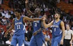 Minnesota Timberwolves guard Andrew Wiggins (22), forward Kevin Garnett (21) and guard Ricky Rubio (9) congratulate each other as they head to the ben