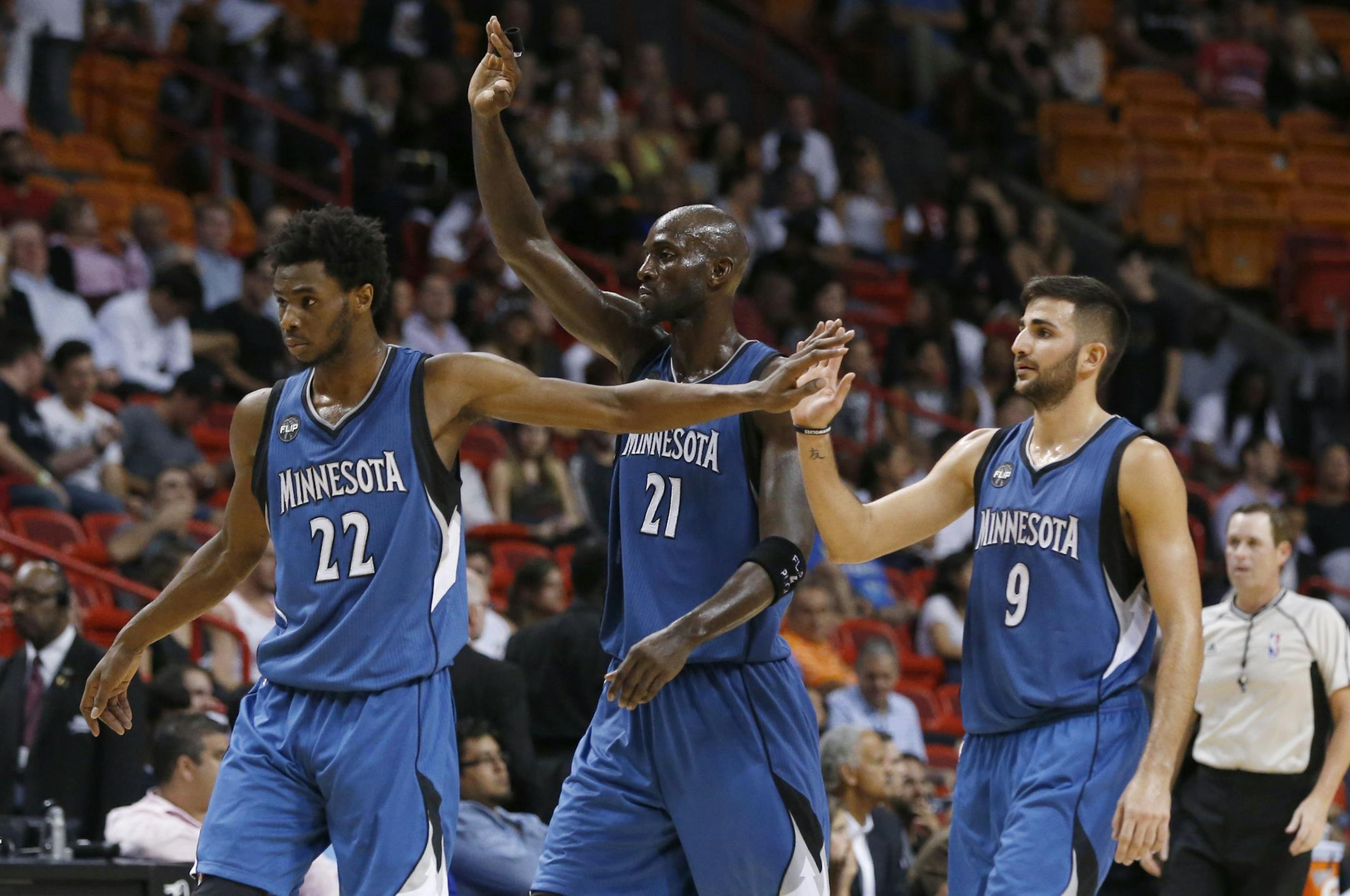 Minnesota Timberwolves guard Andrew Wiggins (22), forward Kevin Garnett (21) and guard Ricky Rubio (9) congratulate each other as they head to the bench area during a time out in the final seconds of the second half of an NBA basketball game against the Miami Heat, Tuesday, Nov. 17, 2015, in Miami. The Timberwolves defeated the Heat 103-91. (AP Photo/Wilfredo Lee)
