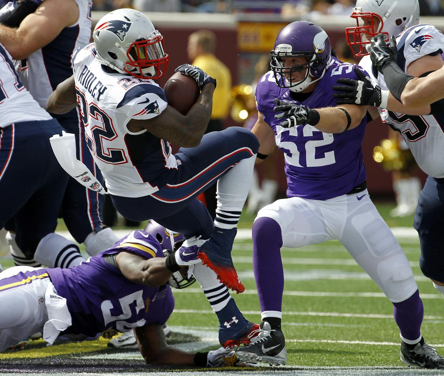 New England Patriots running back Stevan Ridley (22) carries the ball as Minnesota Vikings linebacker Jasper Brinkley and linebacker Chad Greenway (52) defend during the first quarter of an NFL football game Sunday, Sept. 14, 2014, in Minneapolis. (AP Photo/Ann Heisenfelt)