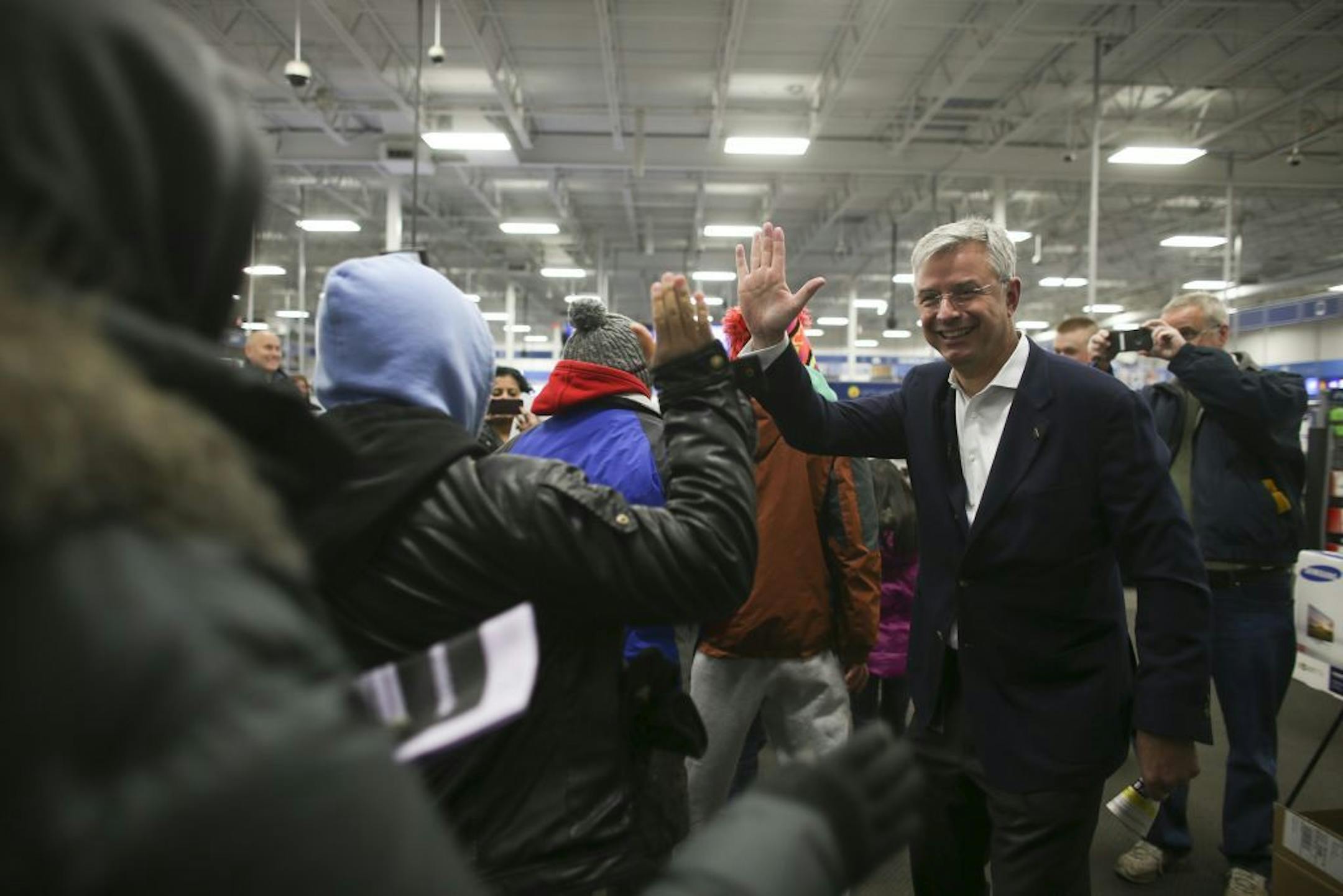 Best Buy CEO Hubert Joly high fived customers as they entered the store to begin their holiday shopping Thursday evening.